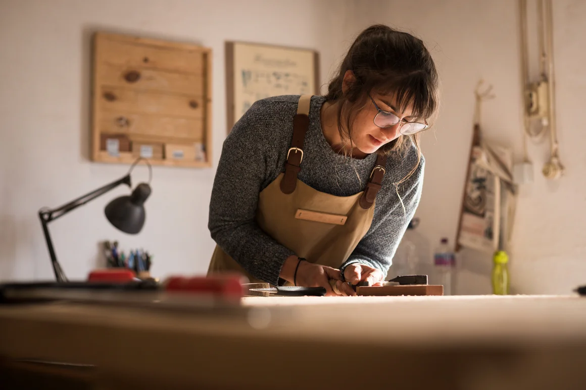 Person bearbeitet Holz an einer Werkbank